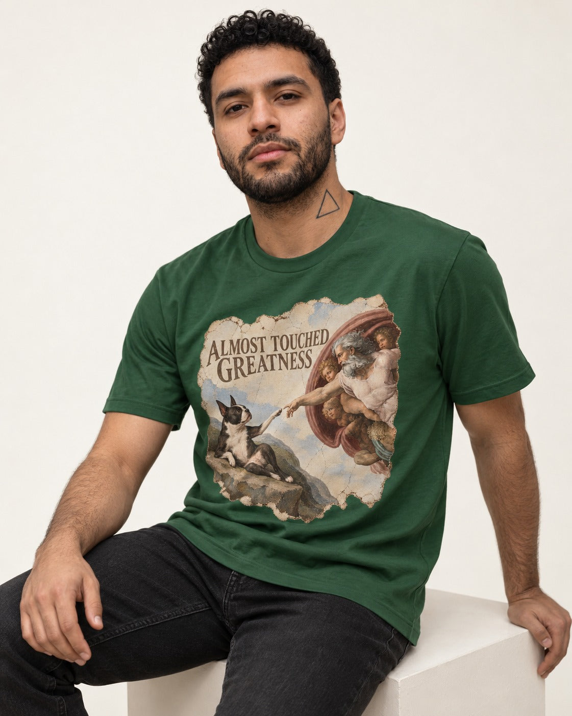 Almost Touched Greatness Boston Terrier Renaissance Parody T-Shirt in Forest Green, worn by a seated model