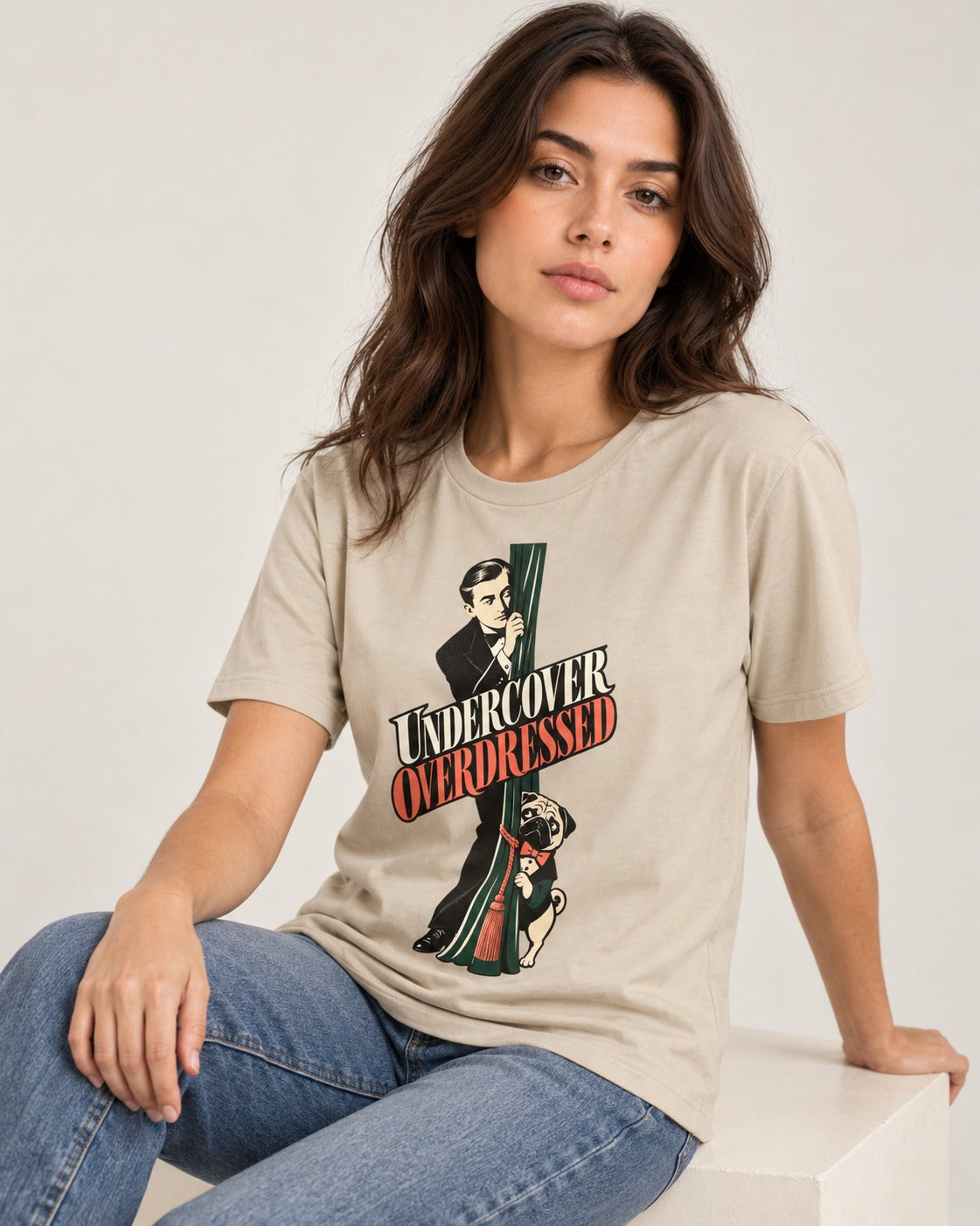 Undercover Overdressed Pug T-Shirt in Sand, worn by a seated model