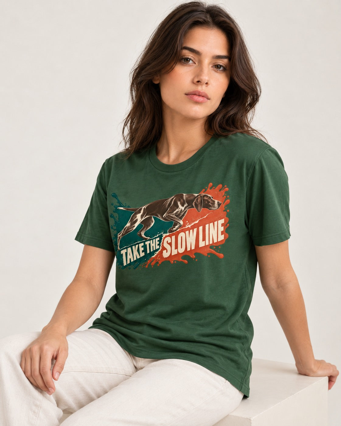 German Shorthaired Pointer Take The Slow Line Paint Splash Graphic T-Shirt in Forest Green, worn by a seated model