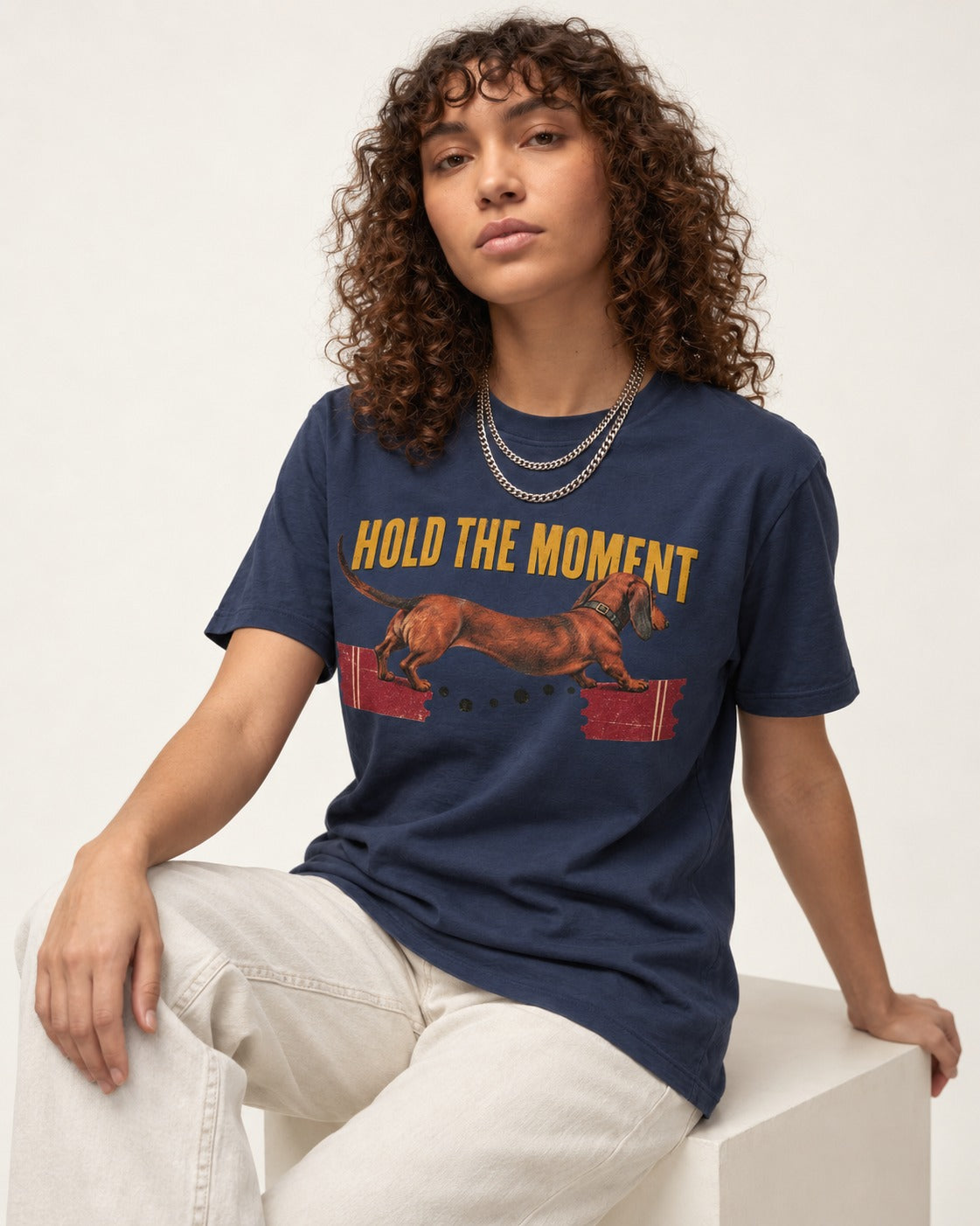 Dachshund Hold The Moment Torn Ticket Bridge Graphic T-Shirt in Navy, worn by a seated model