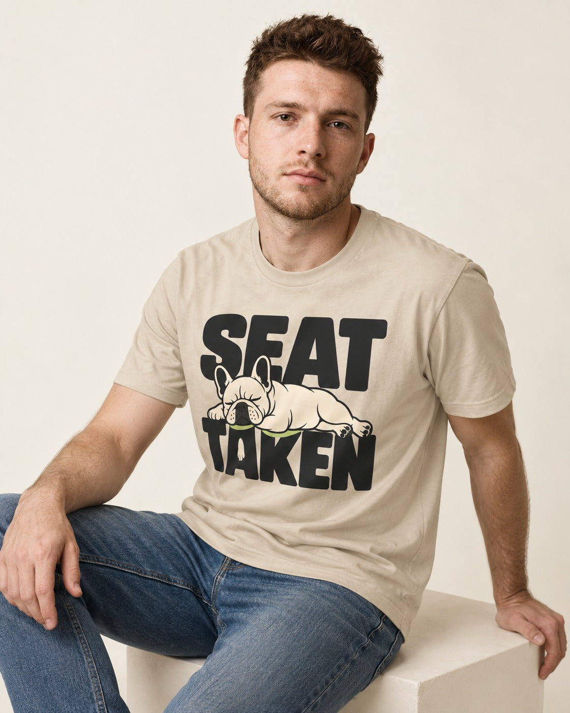 Seat Taken by Frenchie T-Shirt in Sand, worn by a seated model