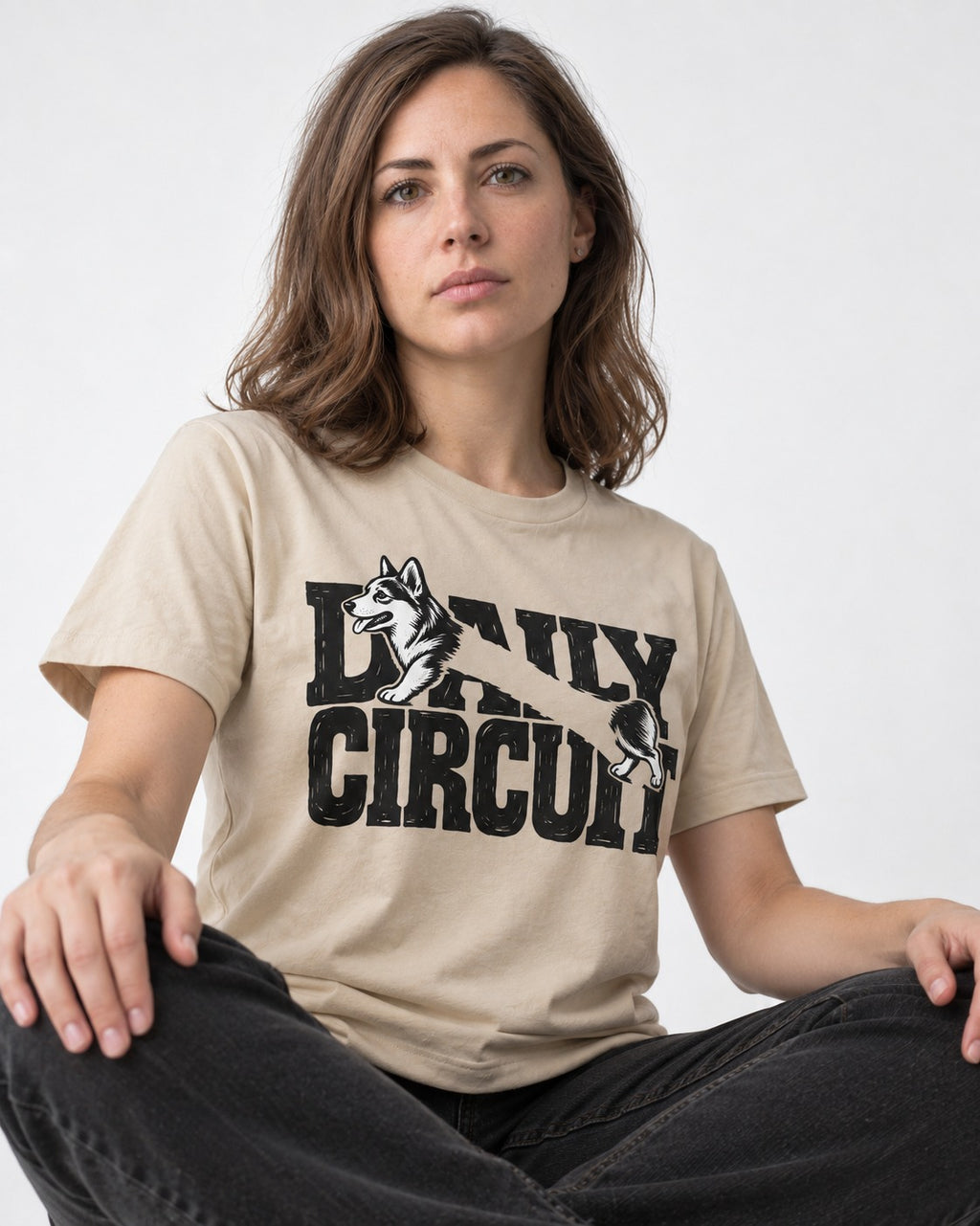 Daily Corgi Circuit T-Shirt in Sand, worn by a seated model