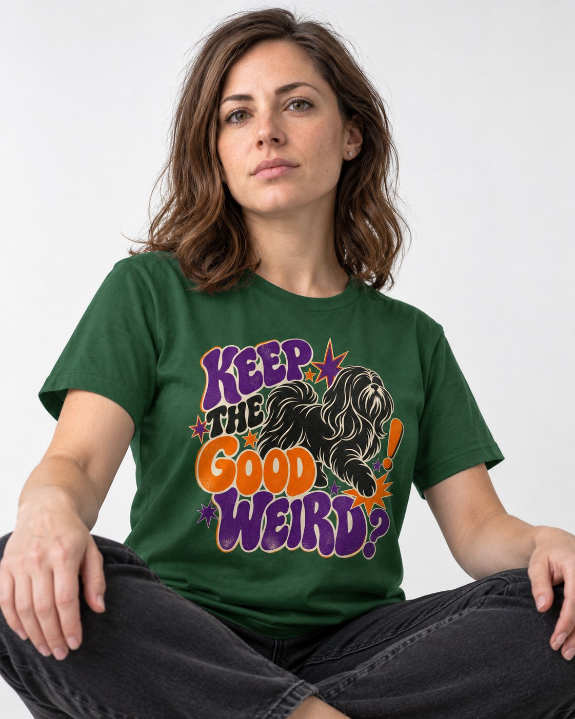 Shih Tzu Keep the Good Weird Retro Typography Graphic T-Shirt in Forest Green, worn by a seated model