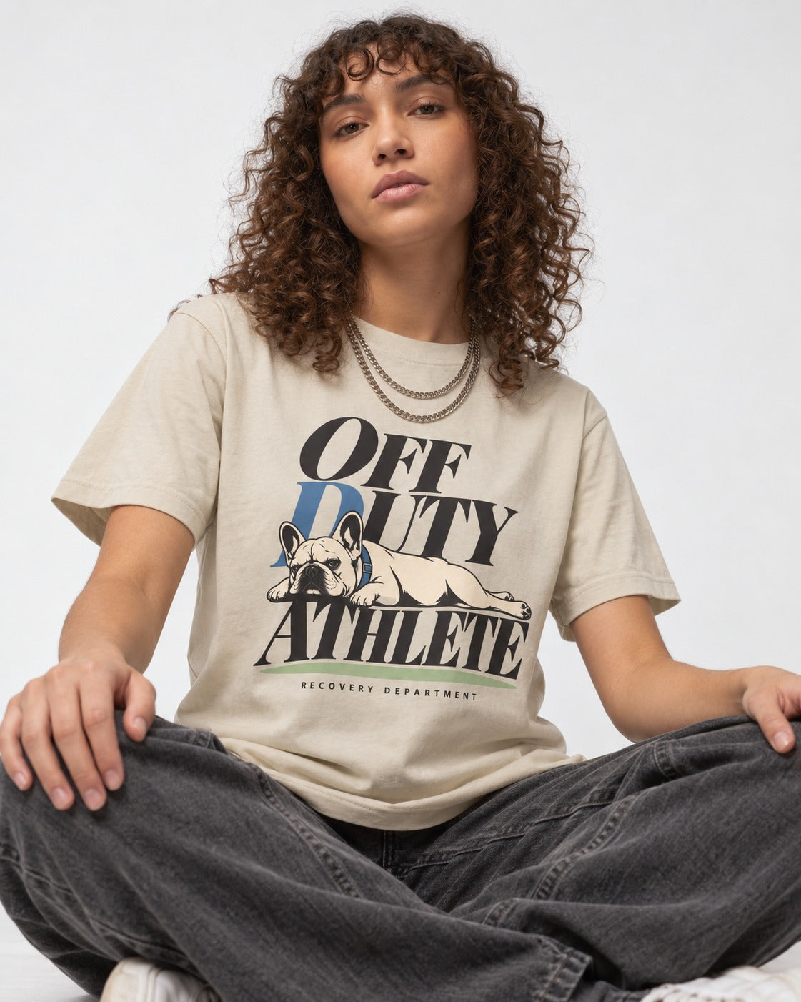 Off Duty Athlete Frenchie T-Shirt in Sand, worn by a seated model