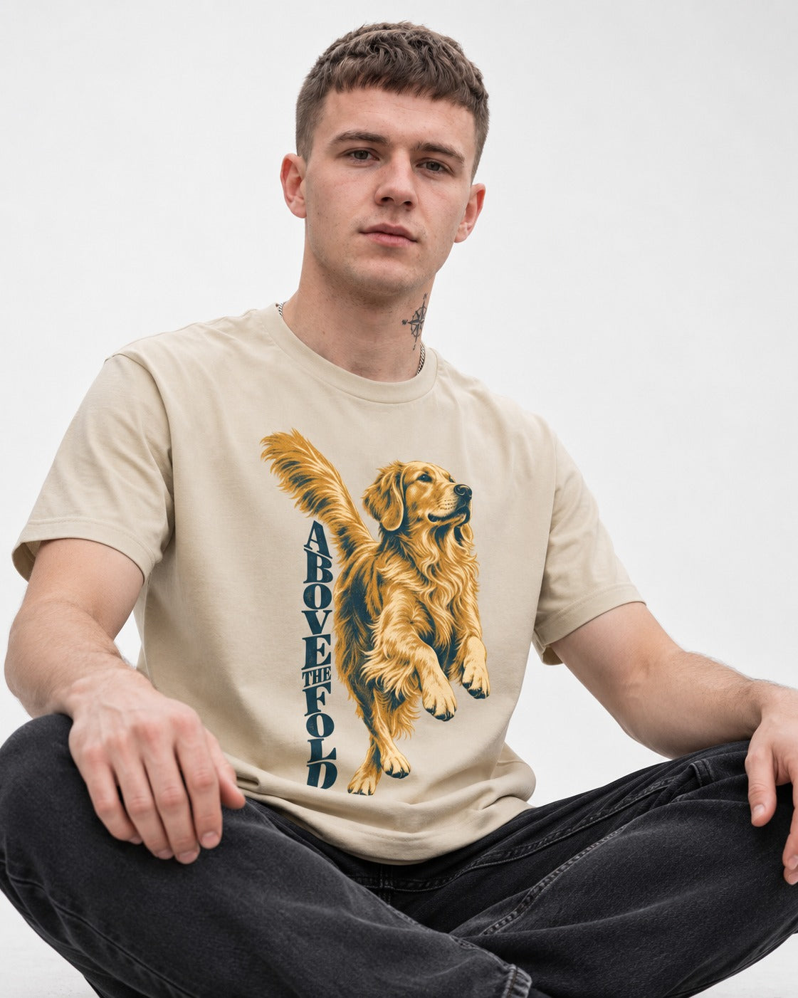 Golden Retriever Above the Fold T-Shirt in Sand, worn by a seated model