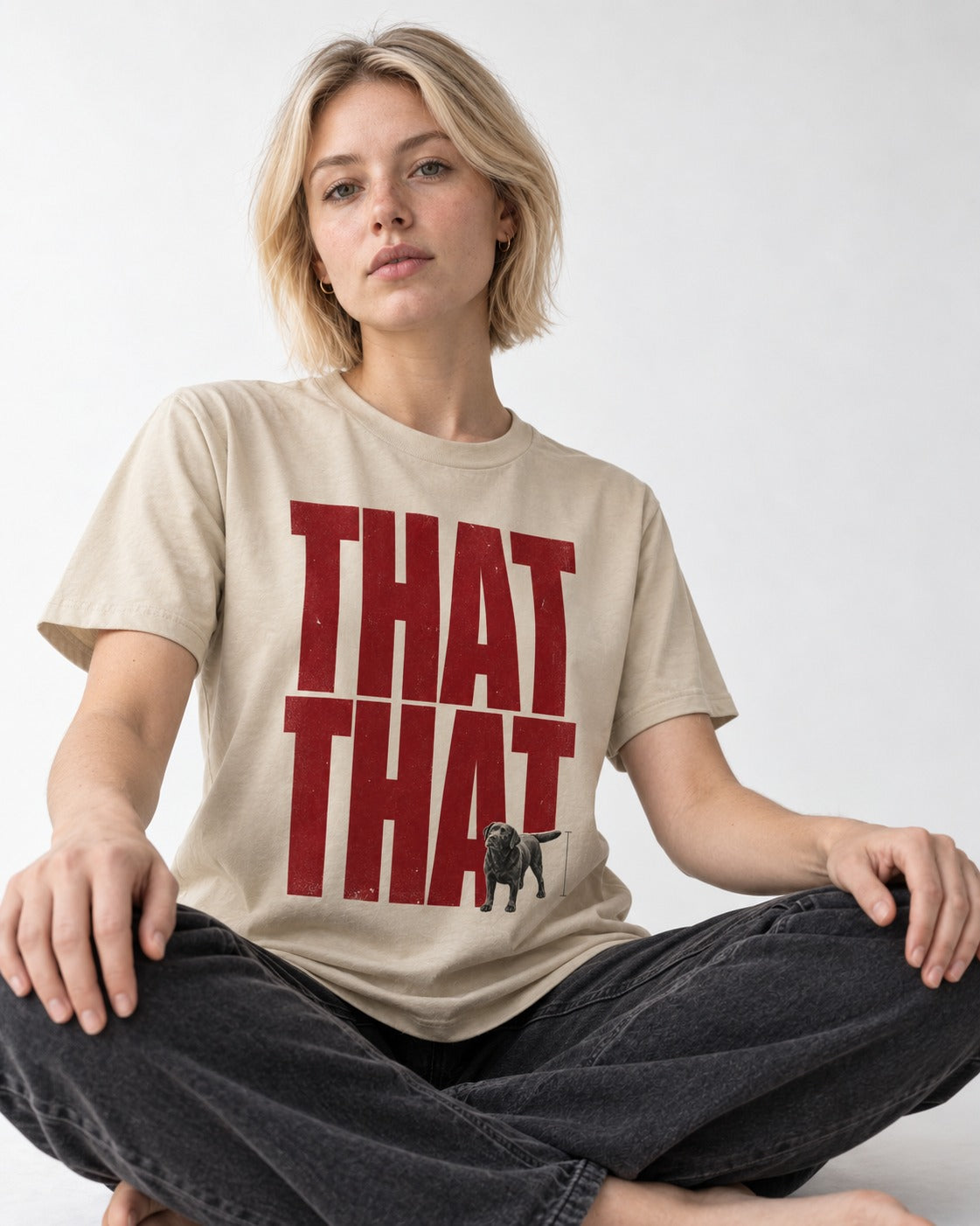 That That Labrador Retriever T-Shirt in Sand, worn by a seated model