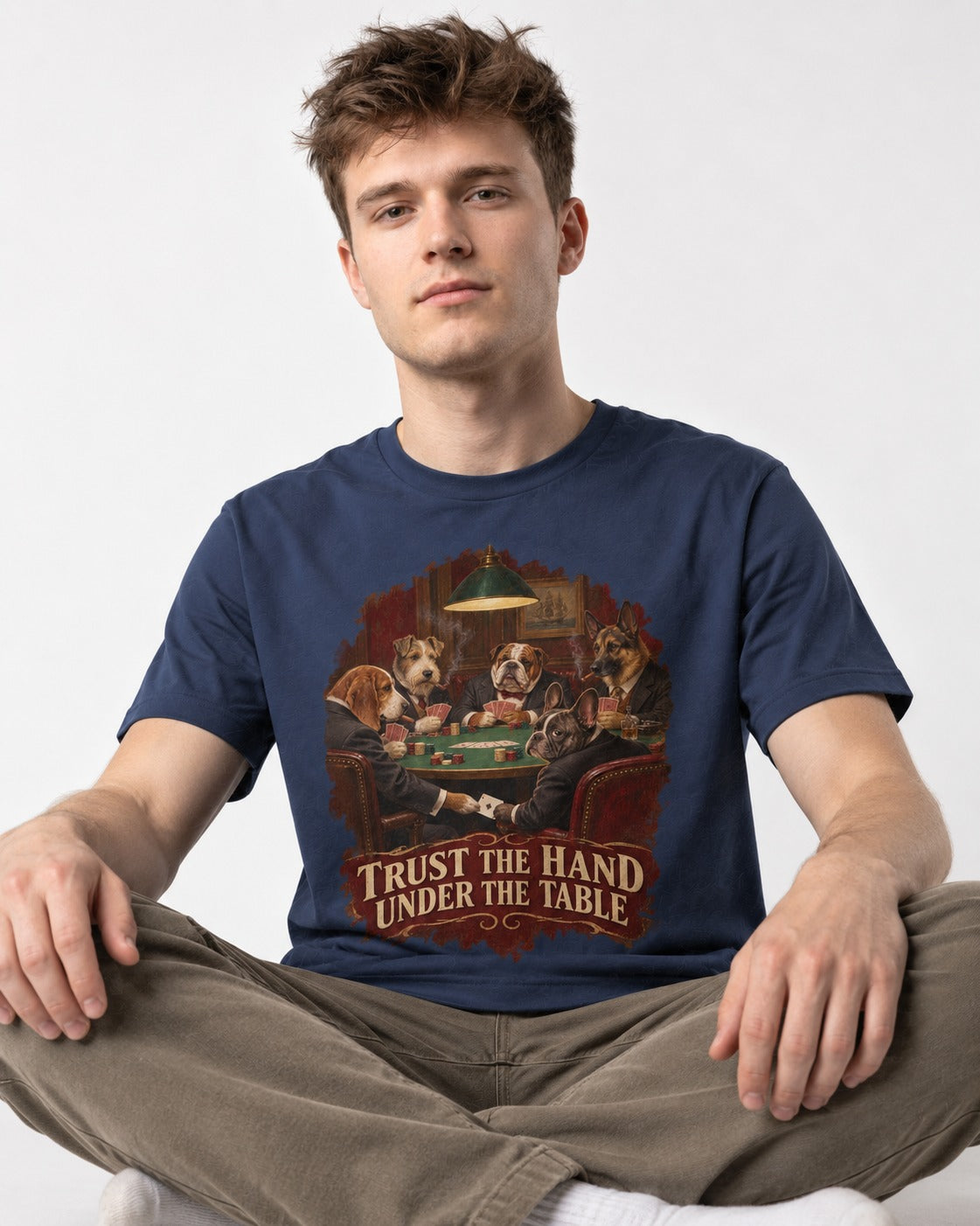 Frenchie Trust the Hand Under the Table Poker Dogs Graphic T-Shirt in Navy, worn by a seated model