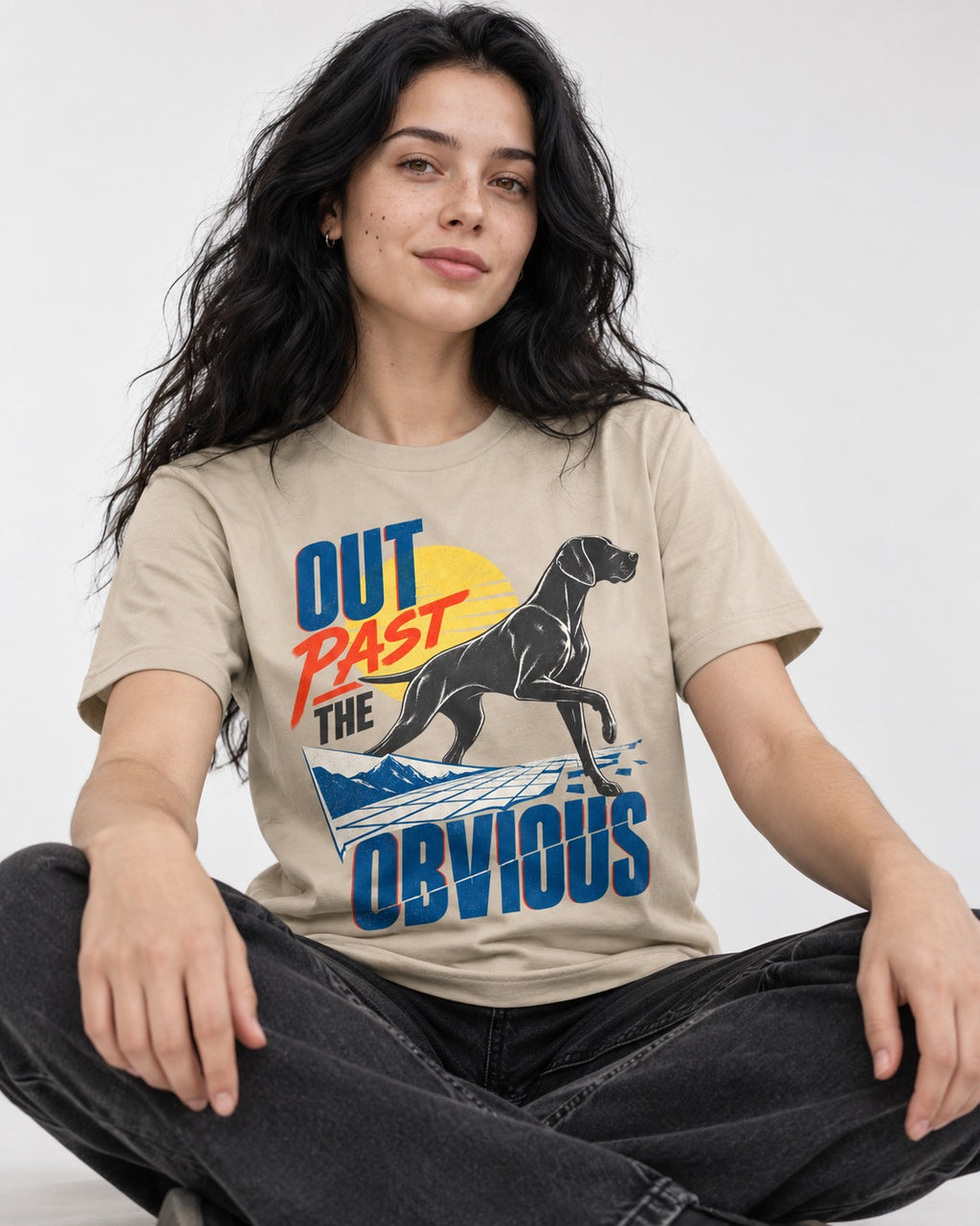 Out Past the Obvious German Shorthaired Pointer T-Shirt in Sand, worn by a seated model