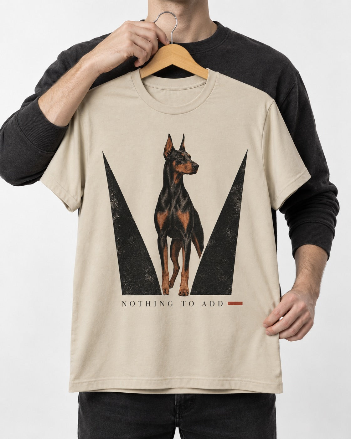 Doberman Nothing to Add T-Shirt in Sand, held up on a hanger