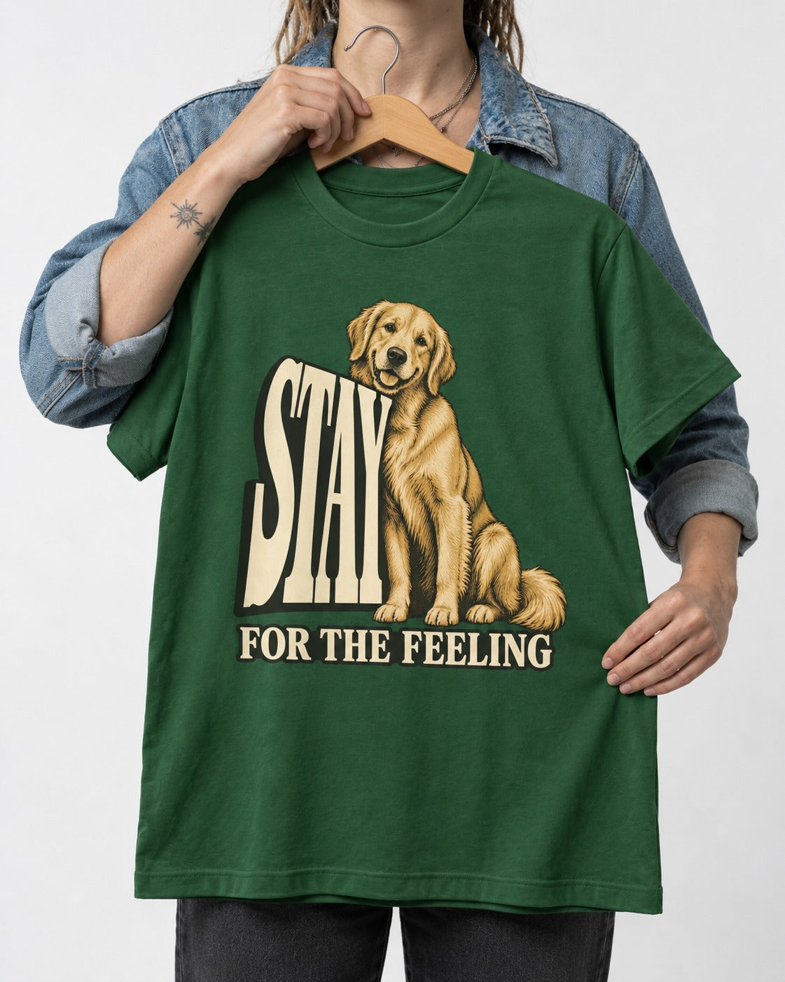 Golden Retriever Stay for the Feeling Leaning Puppy Graphic T-Shirt in Forest Green, held up on a hanger