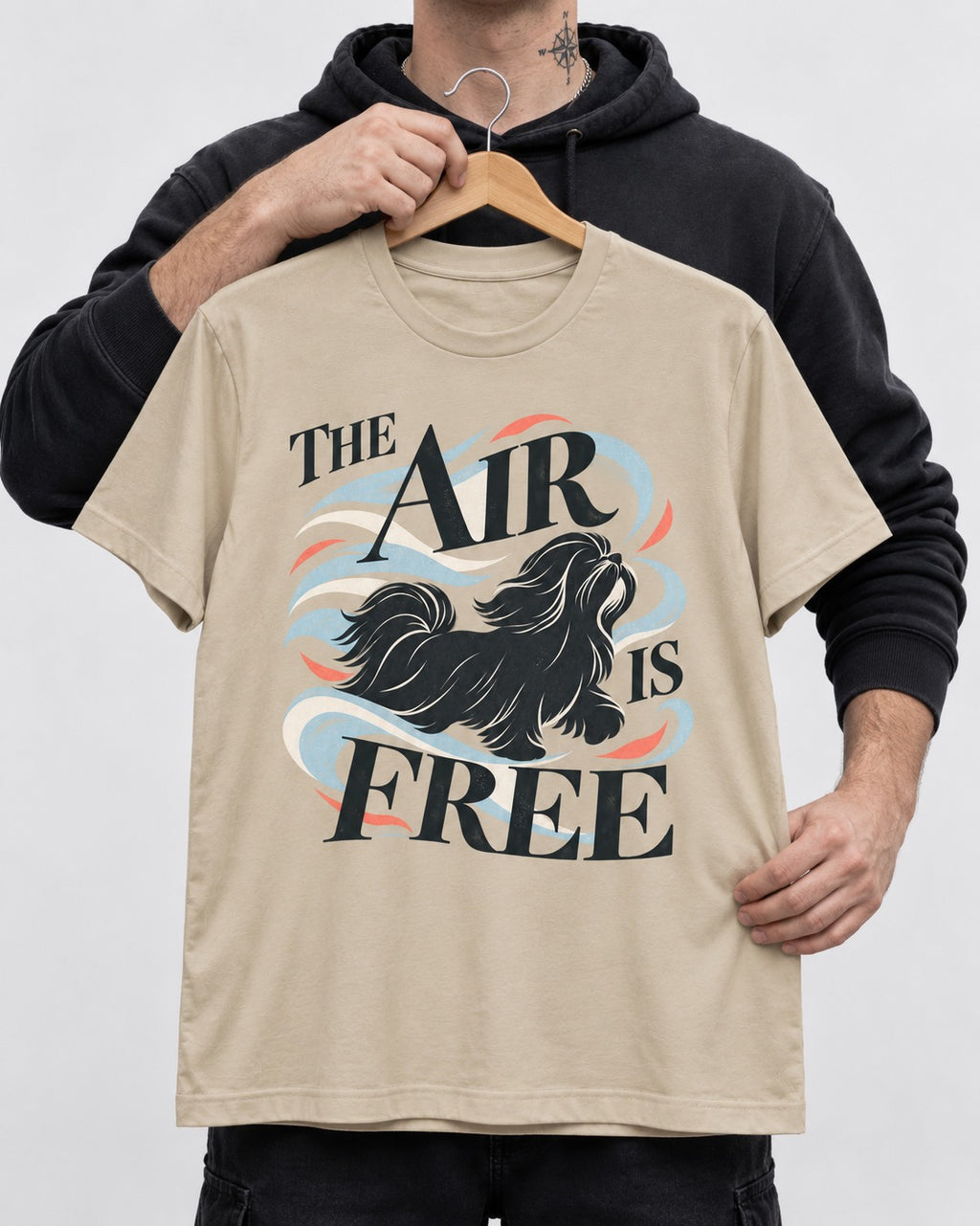The Air Is Free Shih Tzu T-Shirt in Sand, held up on a hanger