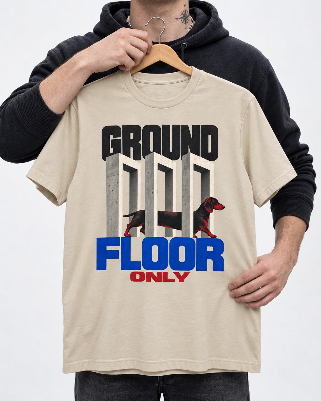 Ground Floor Only Dachshund T-Shirt in Sand, held up on a hanger