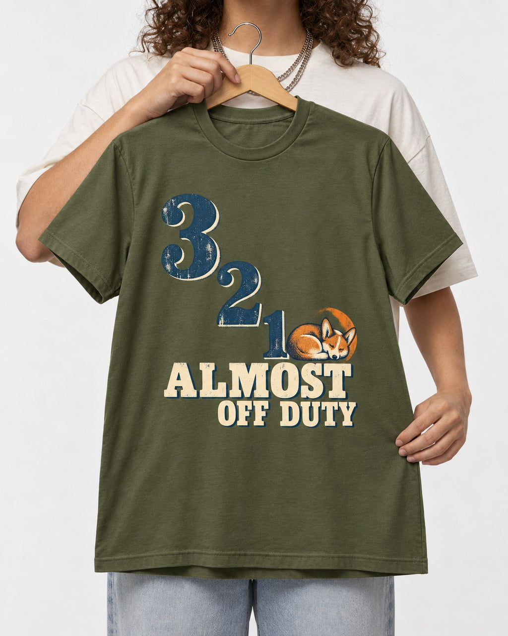 Corgi Almost Off Duty T-Shirt in Heather Military Green, held up on a hanger