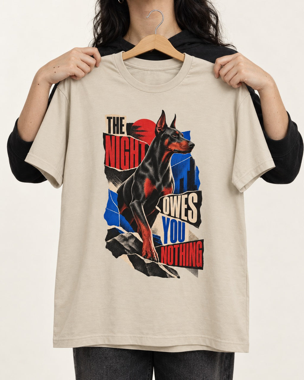 Night Owes You Nothing Doberman T-Shirt in Sand, held up on a hanger