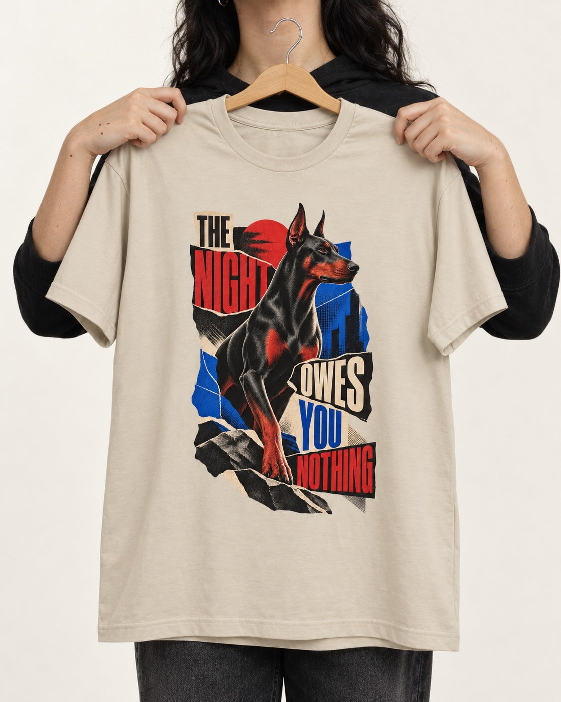 Night Owes You Nothing Doberman T-Shirt in Sand, held up on a hanger