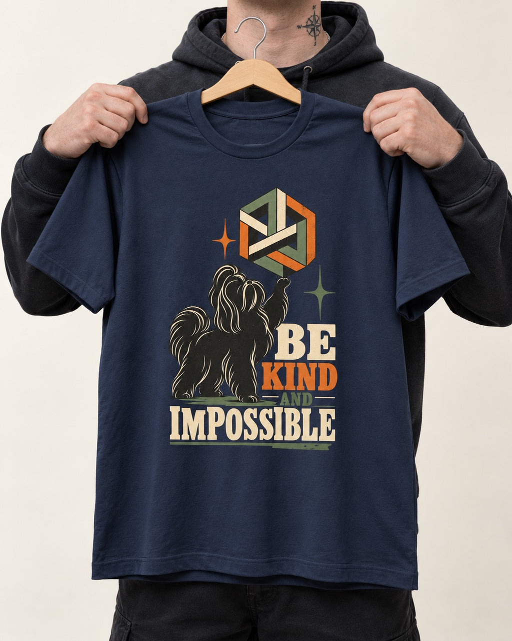 Shih Tzu Be Kind and Impossible Geometric Cube Graphic T-Shirt in Navy, held up on a hanger