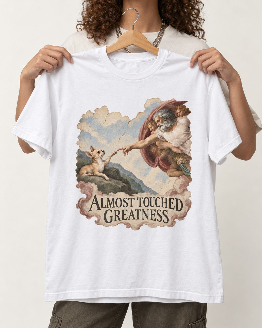 Chihuahua Almost Touched Greatness Renaissance Parody T-Shirt in White, held up on a hanger