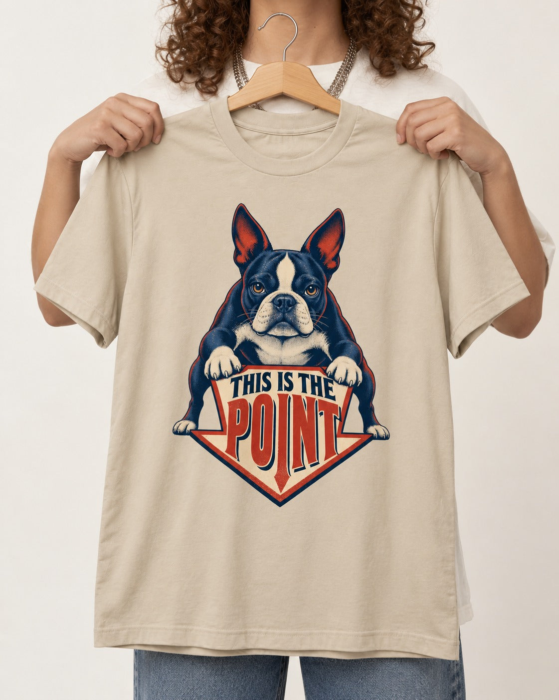 Boston Terrier Is the Point T-Shirt in Sand, held up on a hanger