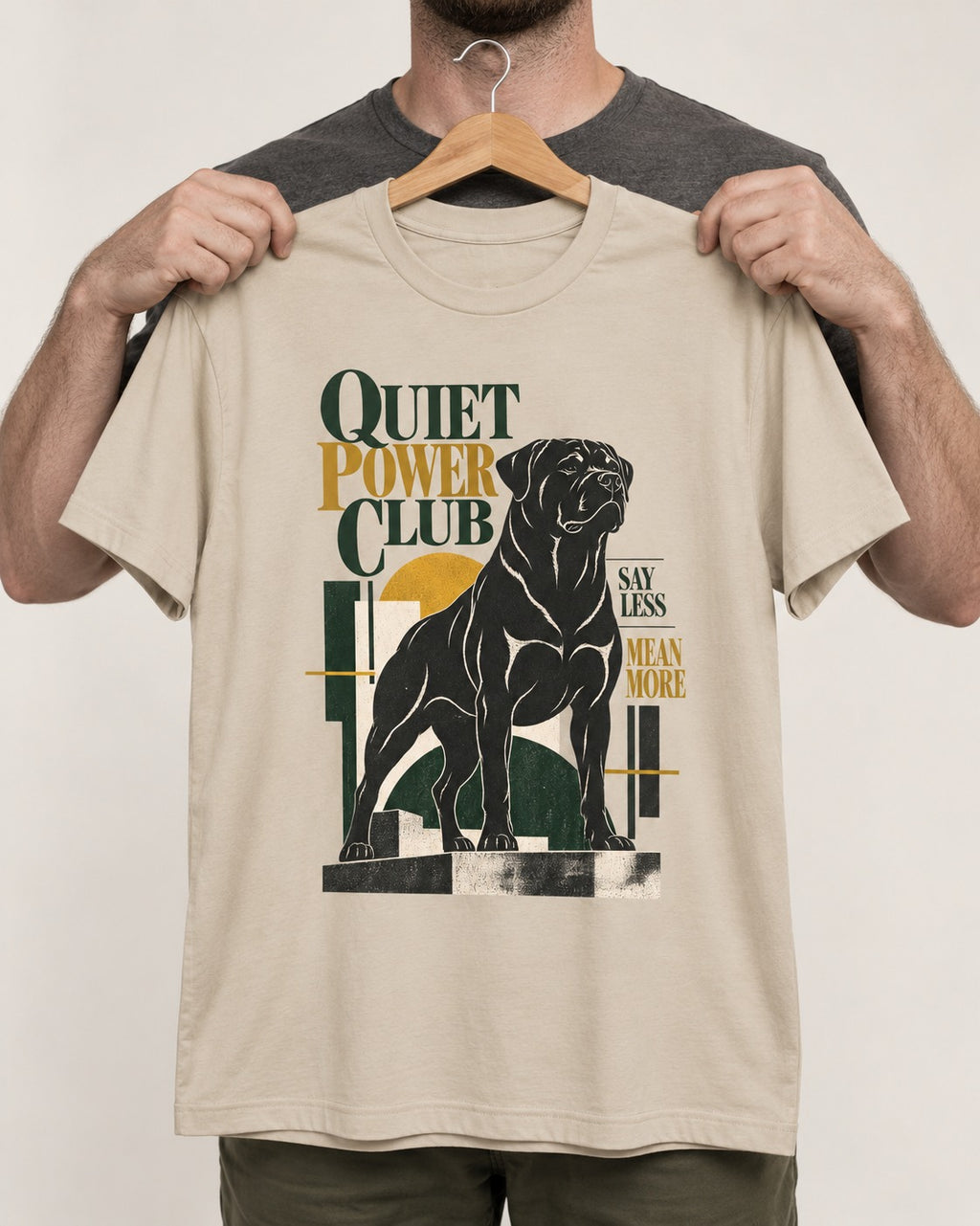 Rottweiler Quiet Power Club T-Shirt in Sand, held up on a hanger