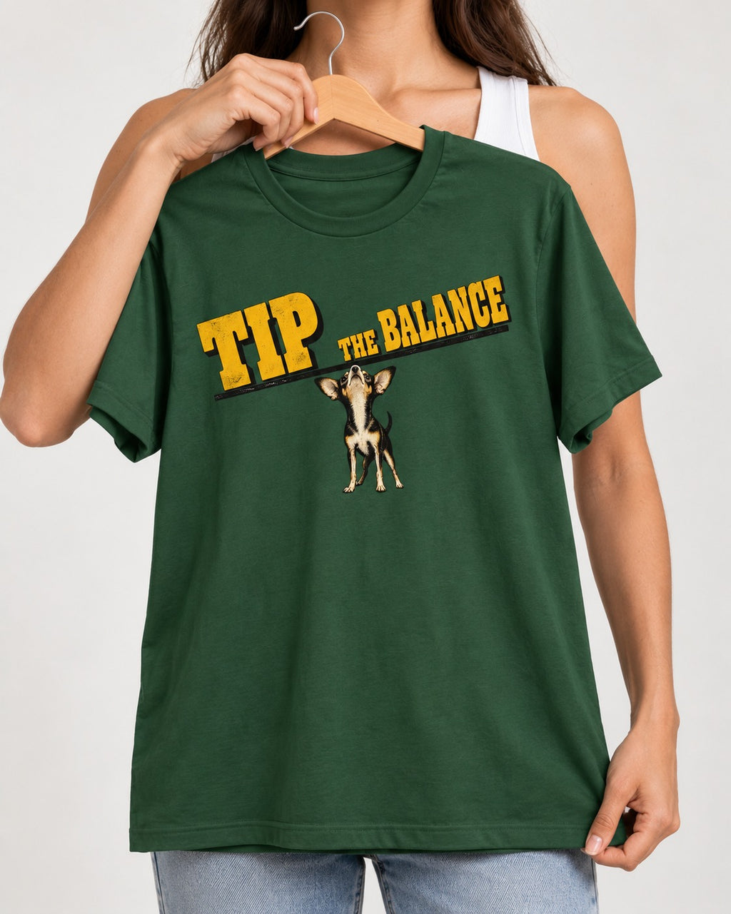Chihuahua Tip the Balance Beam Graphic T-Shirt in Forest Green, held up on a hanger