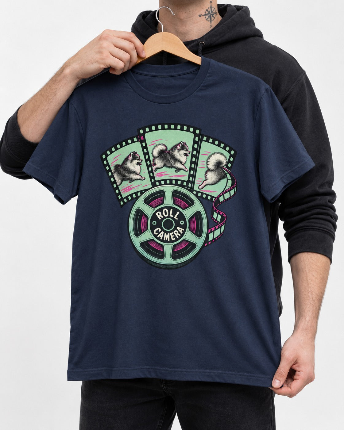 Pomeranian Roll Camera Film Reel Graphic T-Shirt in Navy, held up on a hanger