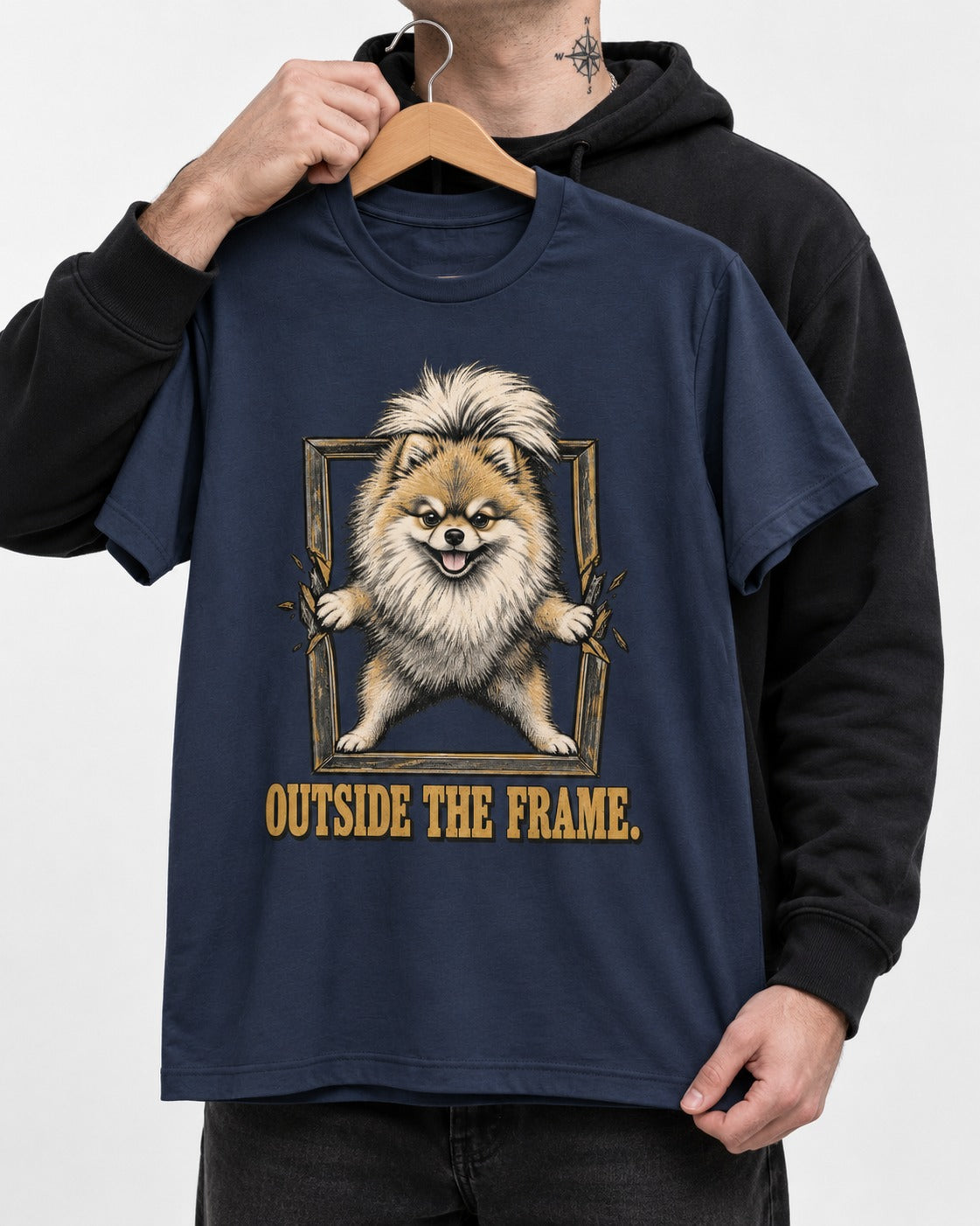 Pomeranian Outside the Frame Breakthrough Graphic T-Shirt in Navy, held up on a hanger