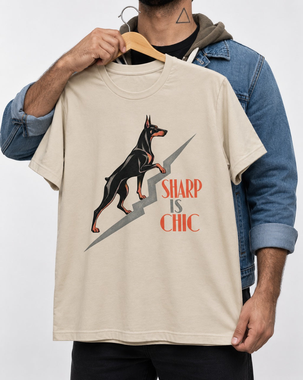 Doberman Is Chic T-Shirt in Sand, held up on a hanger