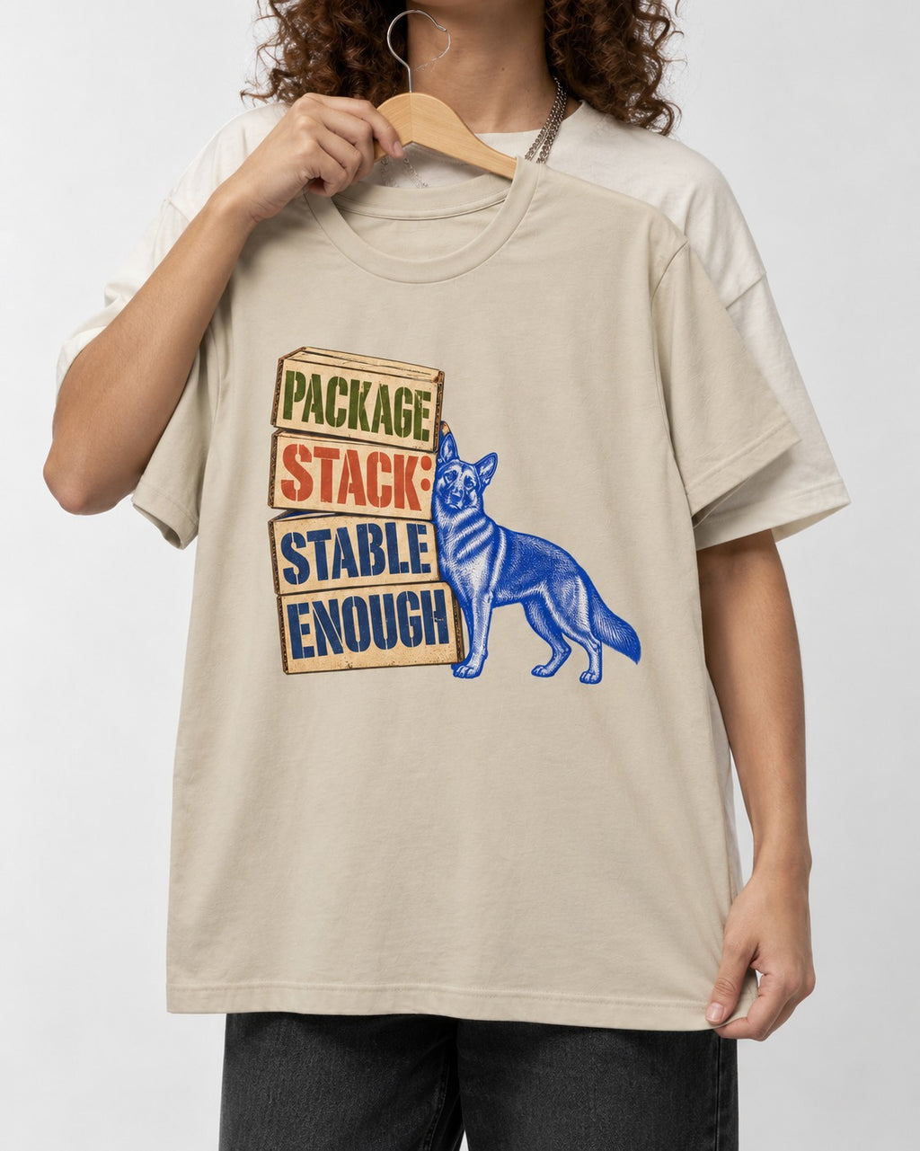 Package Stack Stable Enough German Shepherd Dog T-Shirt in Sand, held up on a hanger