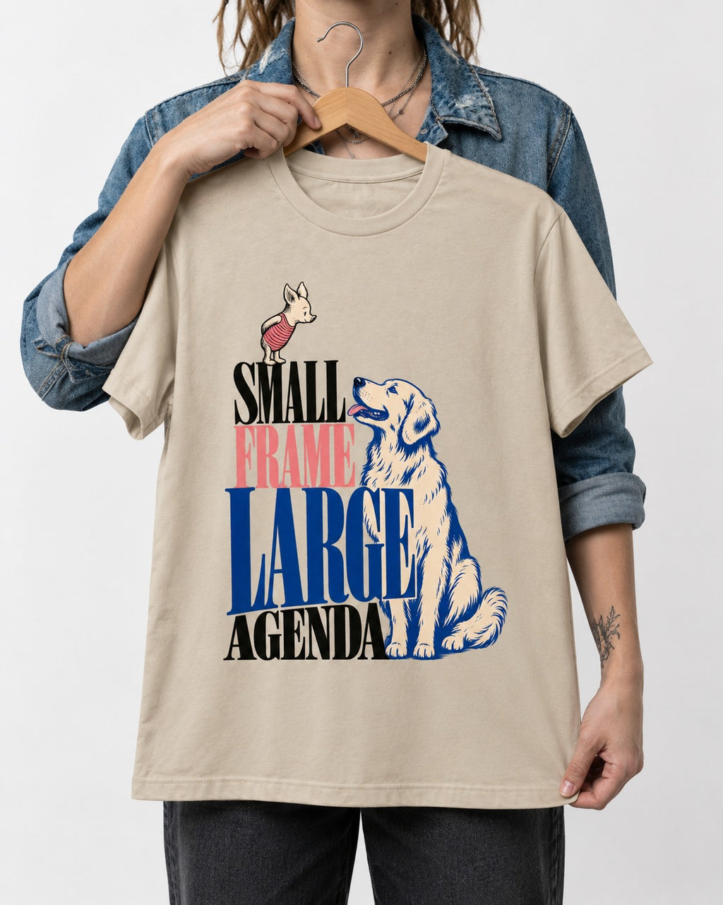 Small Frame Large Agenda Golden Retriever T-Shirt in Sand, held up on a hanger