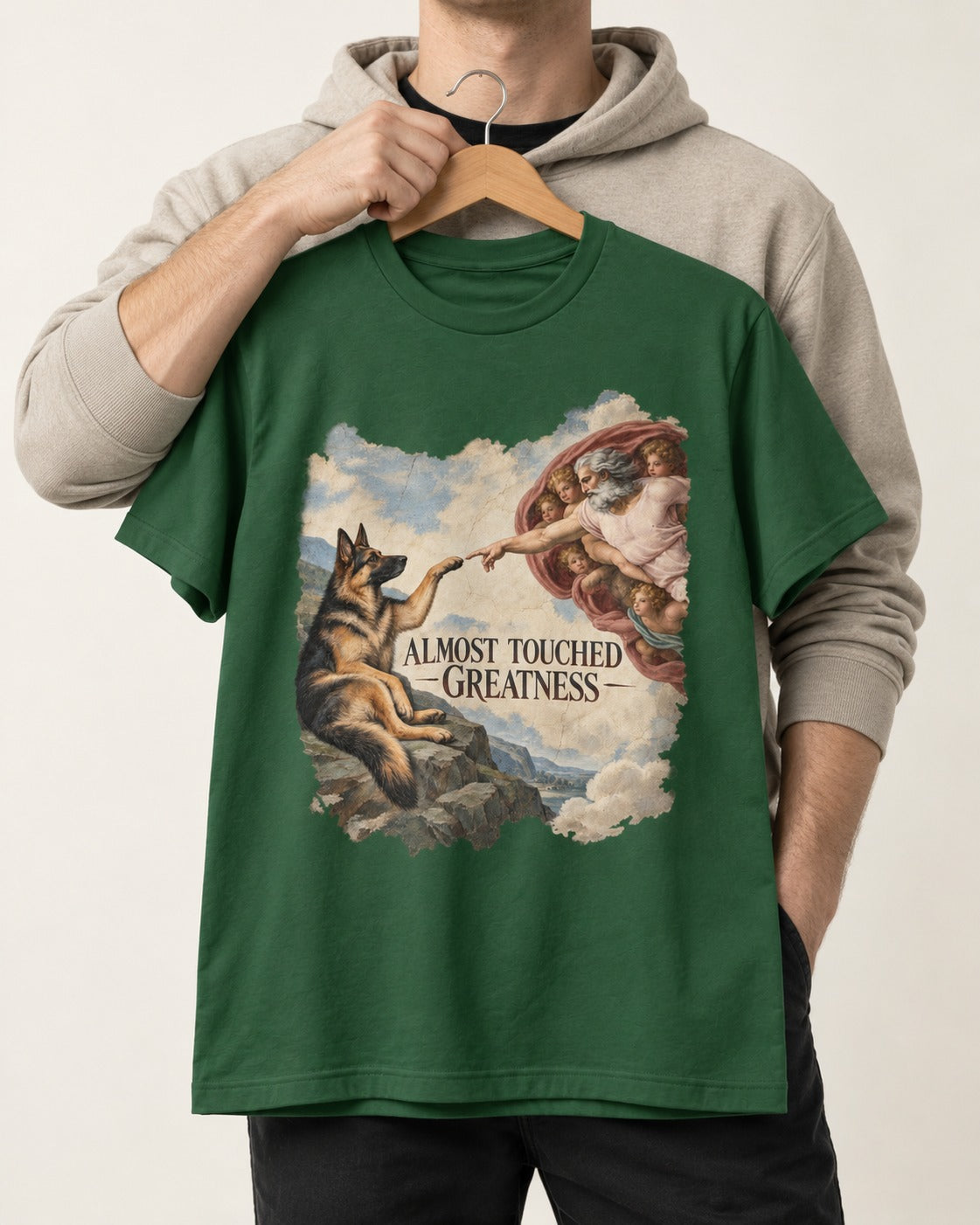 German Shepherd Dog Almost Touched Greatness Creation Parody T-Shirt in Forest Green, held up on a hanger