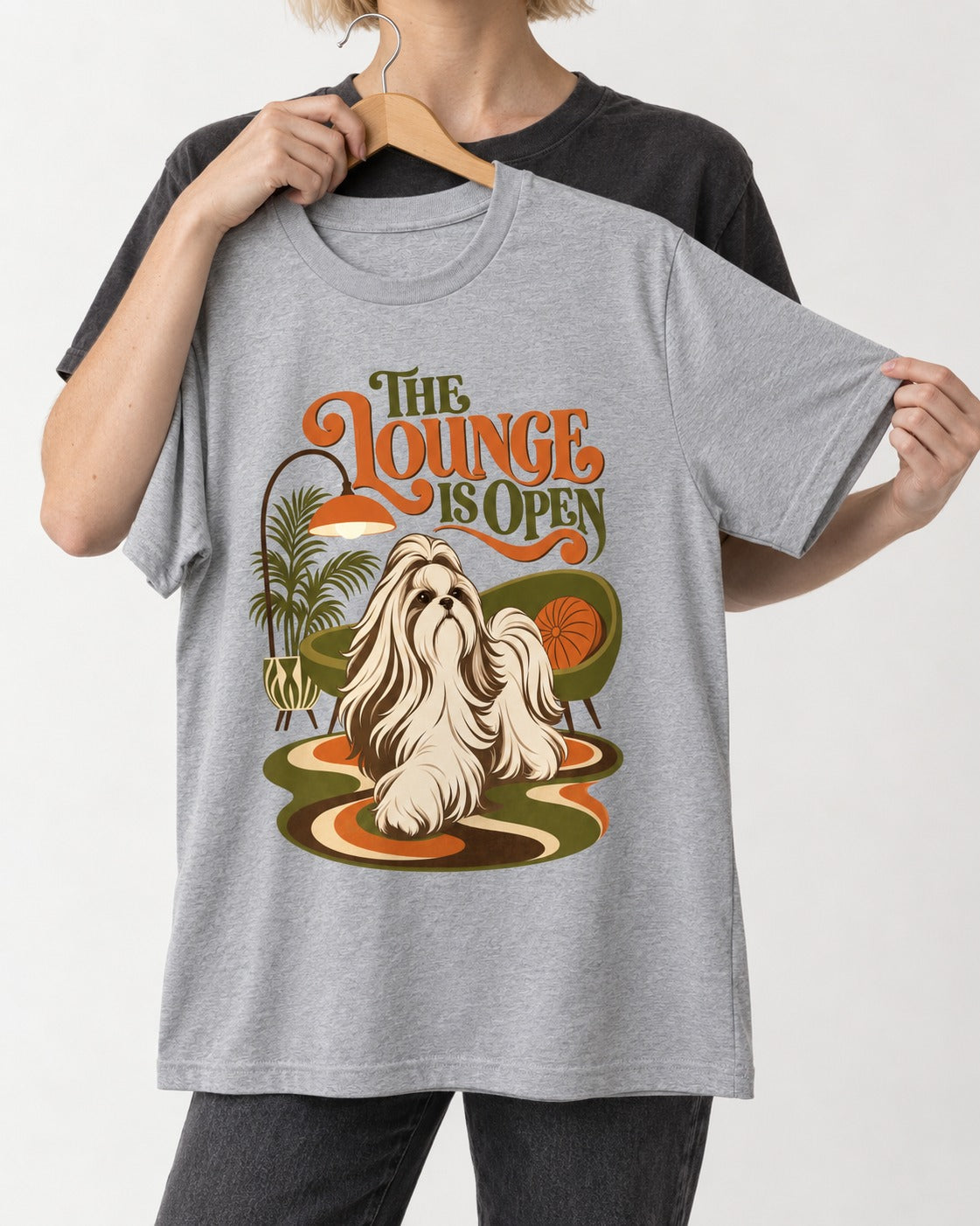 The Shih Tzu Lounge Is Open T-Shirt in Sport Grey, held up on a hanger