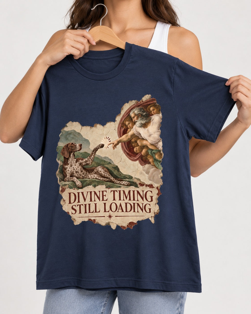 German Shorthaired Pointer Divine Timing Still Loading Creation Scene Graphic T-Shirt in Navy, held up on a hanger