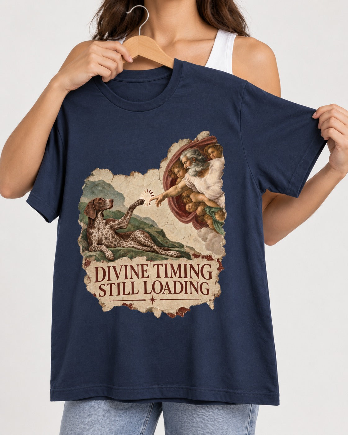German Shorthaired Pointer Divine Timing Still Loading Creation Scene Graphic T-Shirt in Navy, held up on a hanger