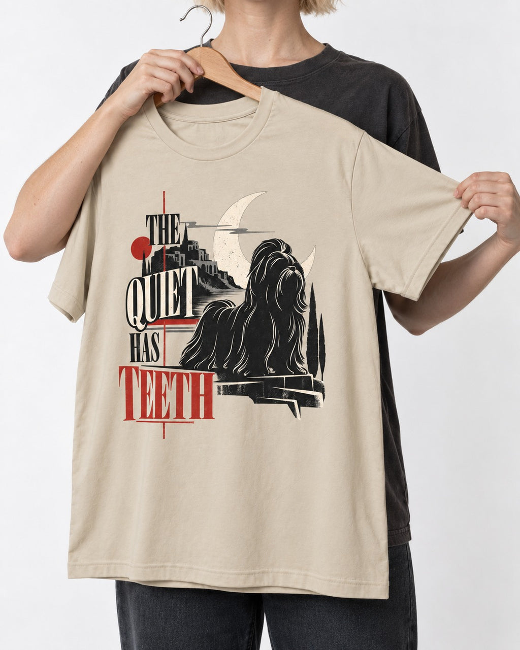 The Quiet Shih Tzu Has Teeth T-Shirt in Sand, held up on a hanger