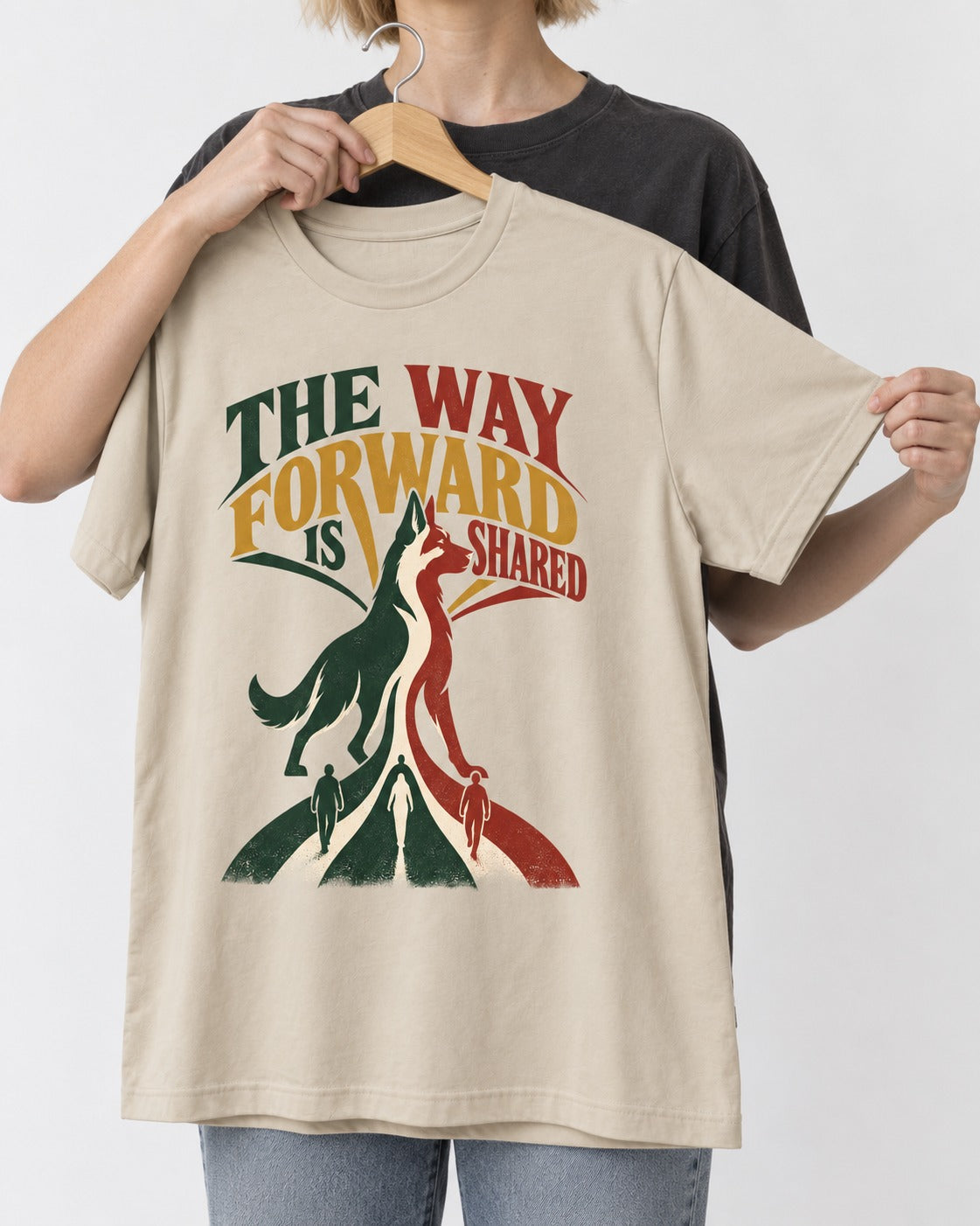 Shared Way Forward German Shepherd Dog T-Shirt in Sand, held up on a hanger