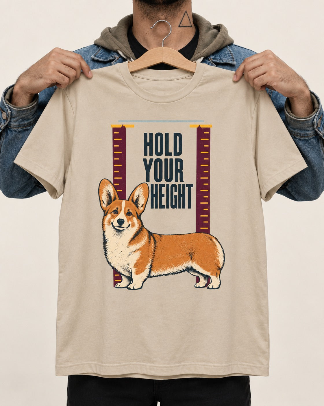 Corgi Hold Your Height T-Shirt in Sand, held up on a hanger