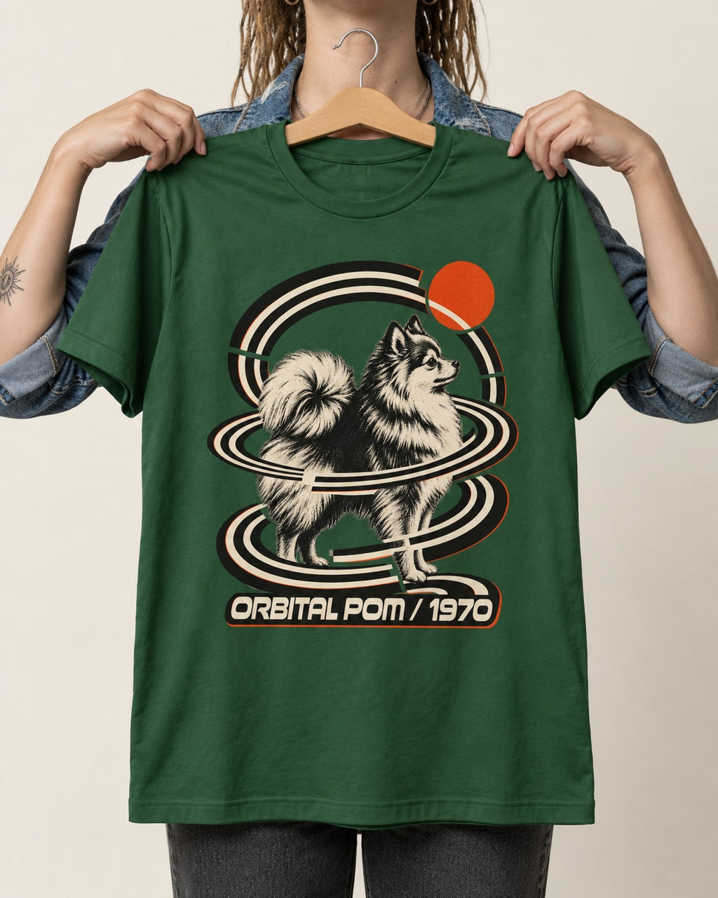 Pomeranian Orbital Pom 1970 Space Age Graphic T-Shirt in Forest Green, held up on a hanger