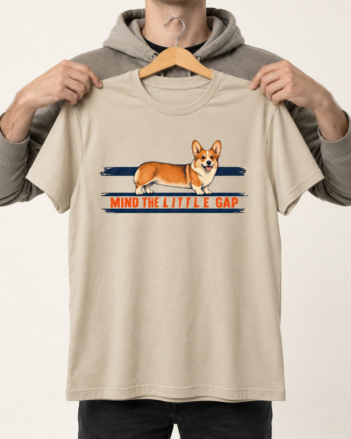 Mind the Little Corgi Gap T-Shirt in Sand, held up on a hanger