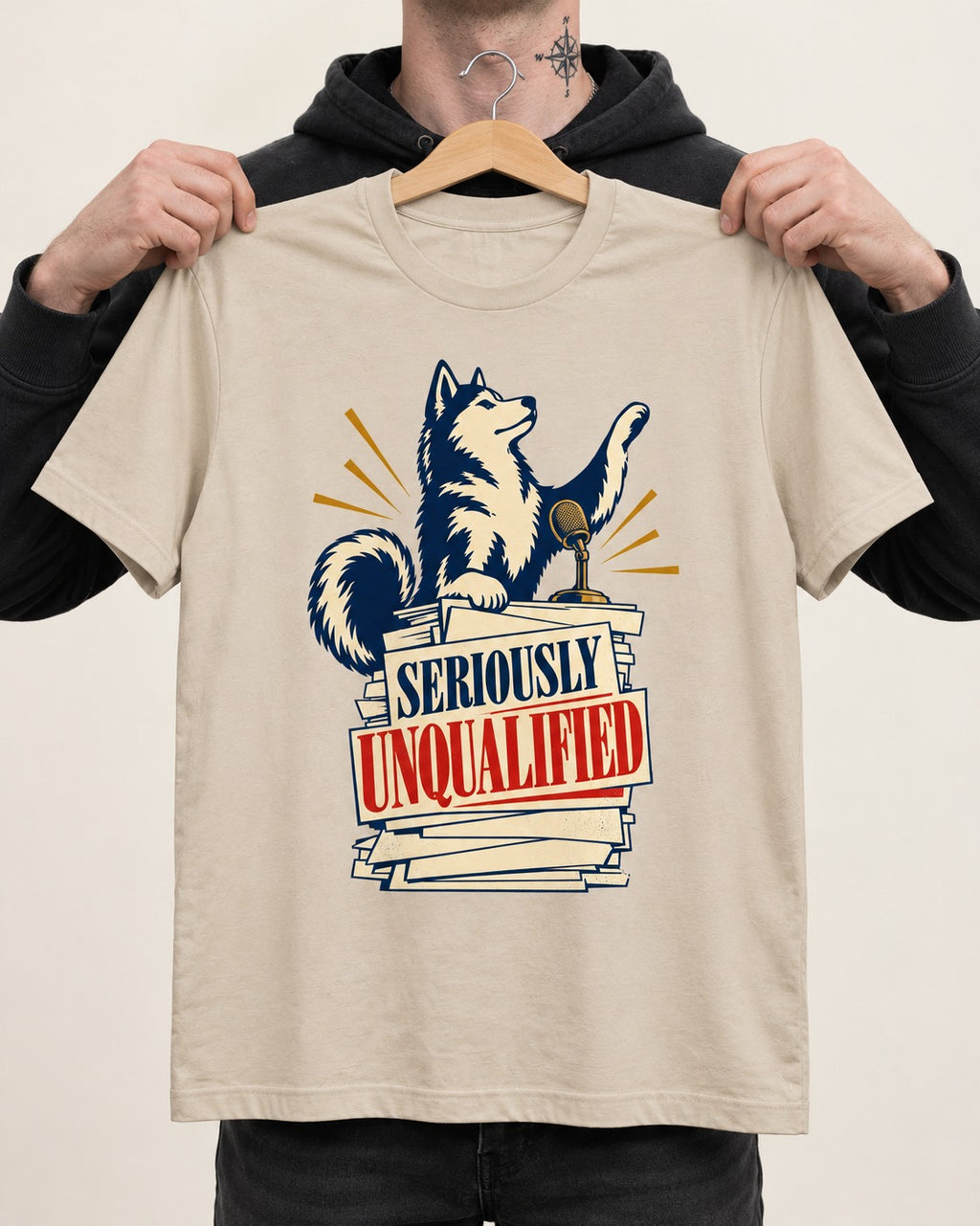 Seriously Unqualified Husky T-Shirt in Sand, held up on a hanger
