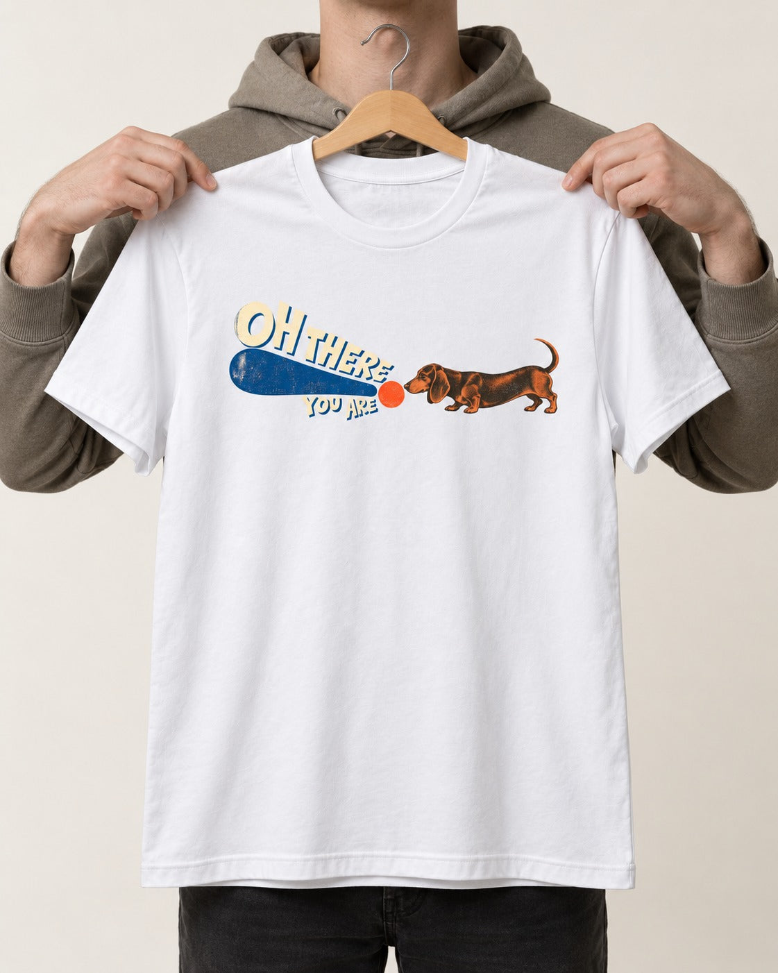 Dachshund Oh There You Are Ball Graphic T-Shirt in White, held up on a hanger