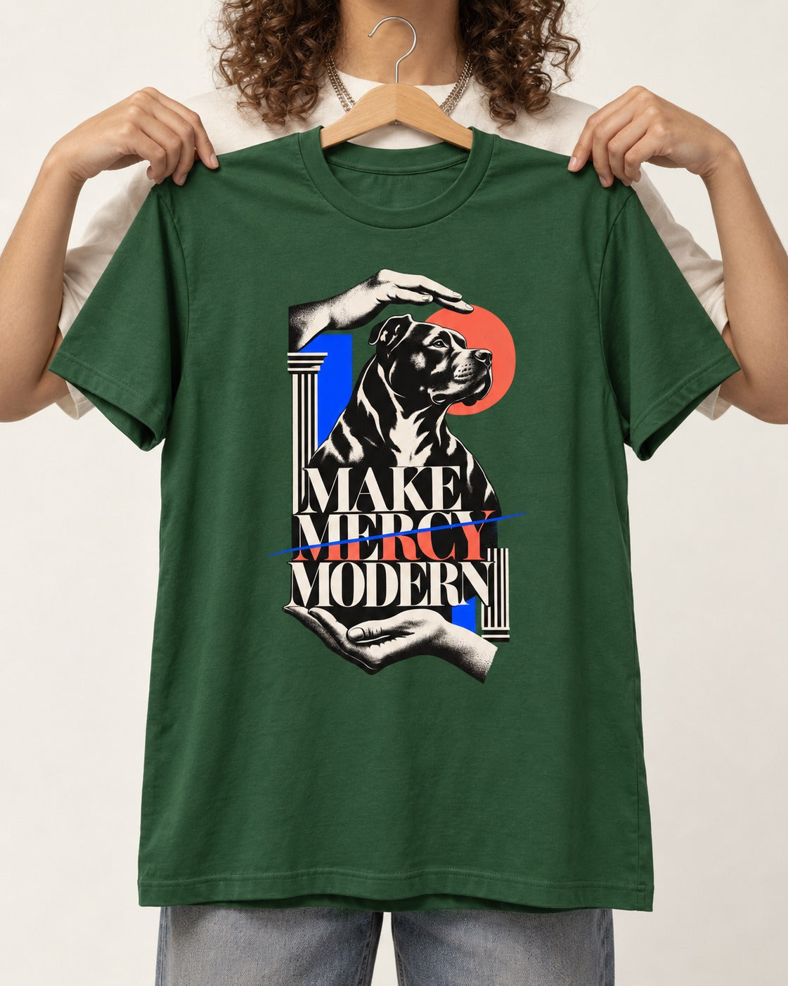 Pitbull Make Mercy Modern Protective Hands Graphic T-Shirt in Forest Green, held up on a hanger