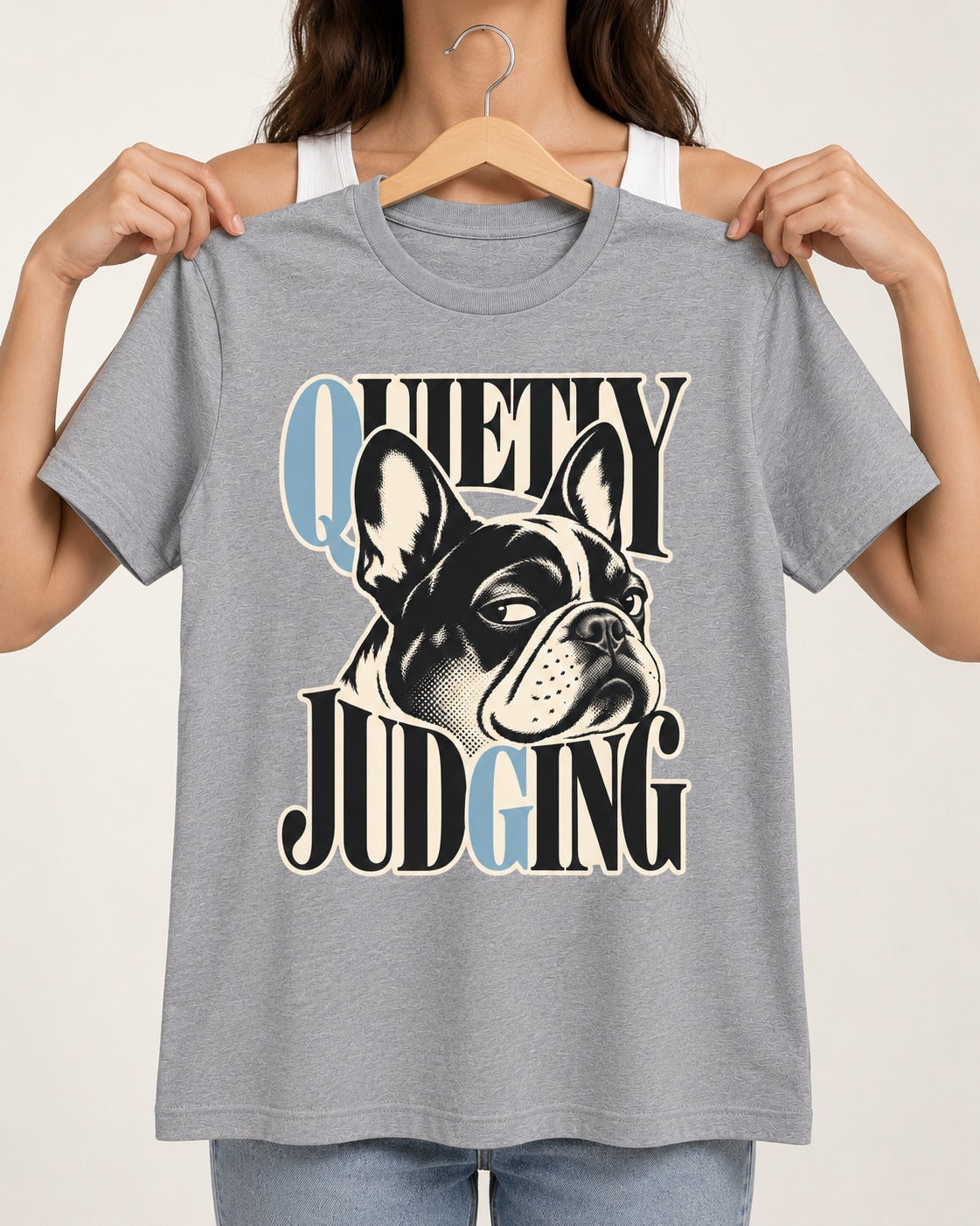 Quietly Judging Frenchie T-Shirt in Sport Grey, held up on a hanger