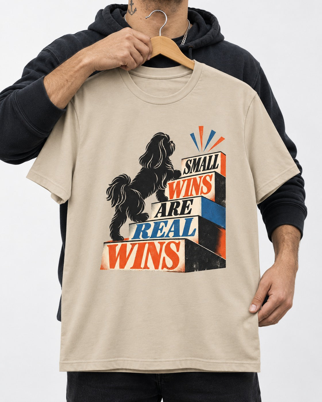 Small Wins Shih Tzu T-Shirt in Sand, held up on a hanger