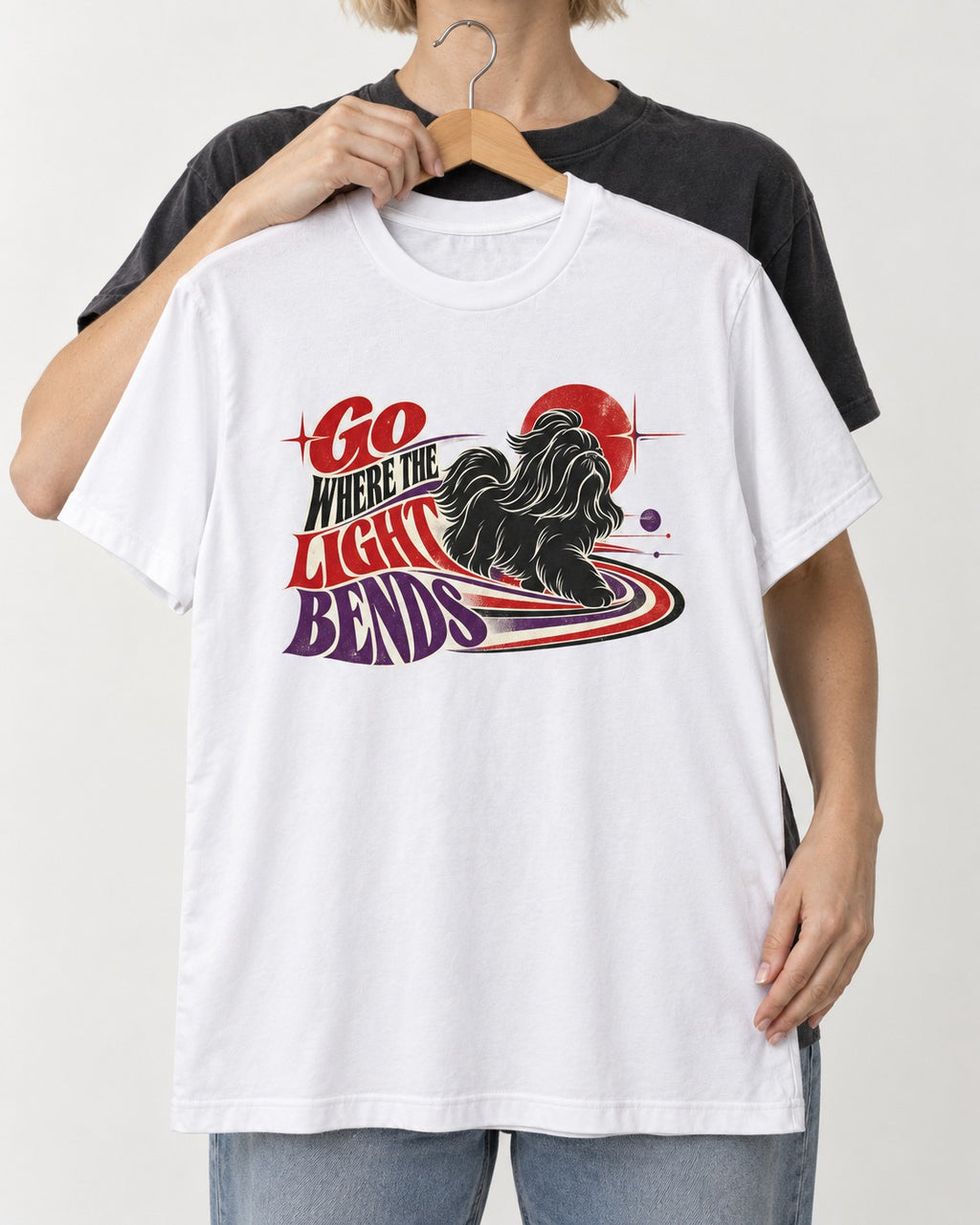 Shih Tzu Go Where the Light Bends Cosmic Orbit Graphic T-Shirt in White, held up on a hanger