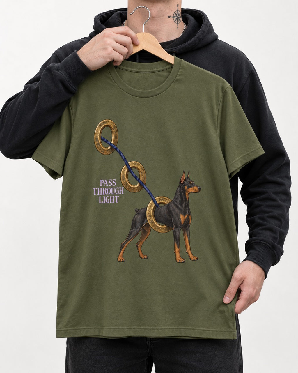 Doberman Pass Through Light Ring Graphic T-Shirt in Heather Military Green, held up on a hanger