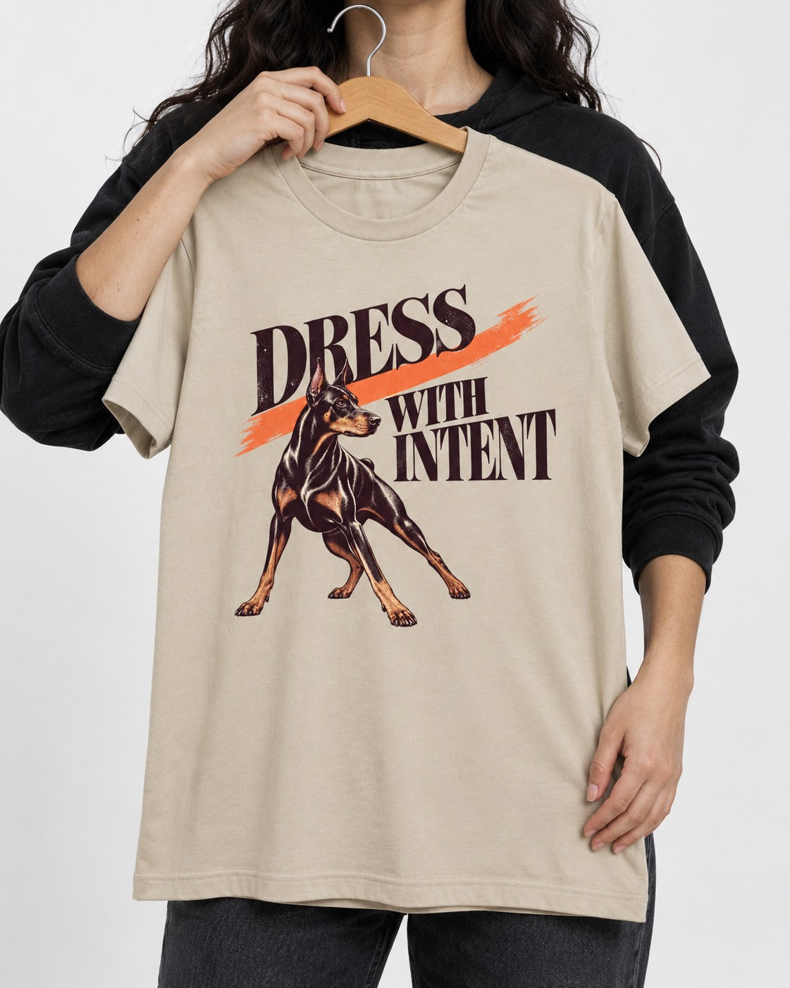 Doberman Dress with Intent T-Shirt in Sand, held up on a hanger