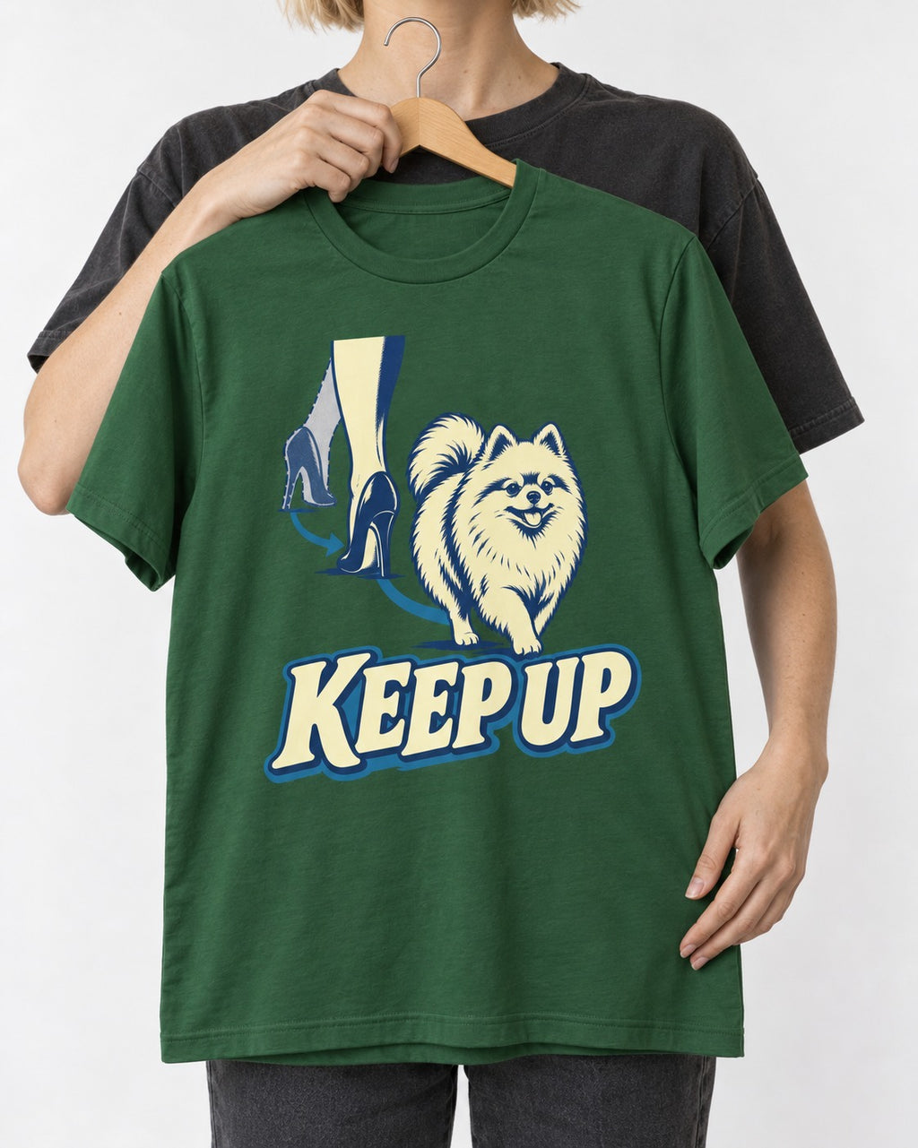 Pomeranian Keep Up High Heel Chase Graphic T-Shirt in Forest Green, held up on a hanger
