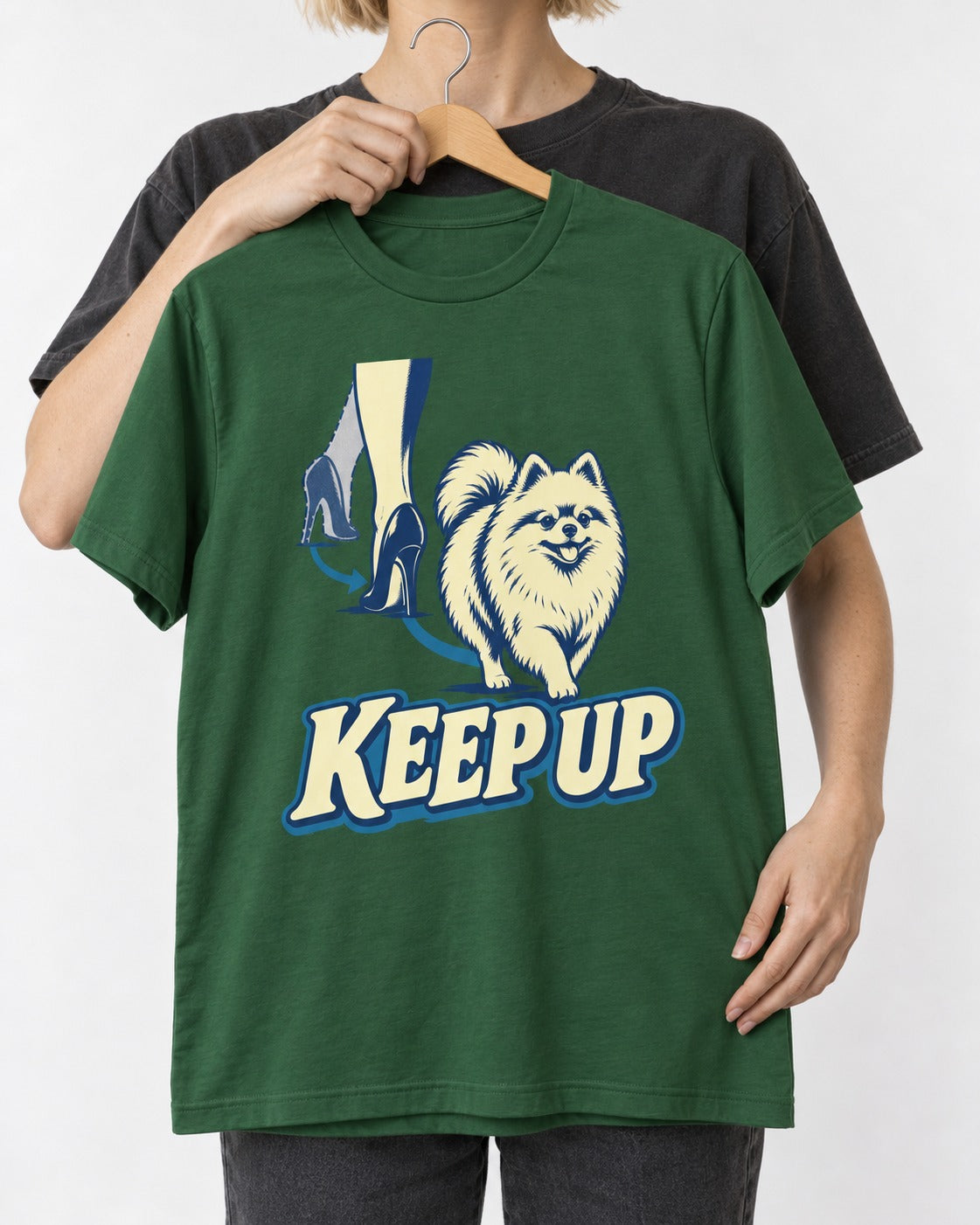 Pomeranian Keep Up High Heel Chase Graphic T-Shirt in Forest Green, held up on a hanger