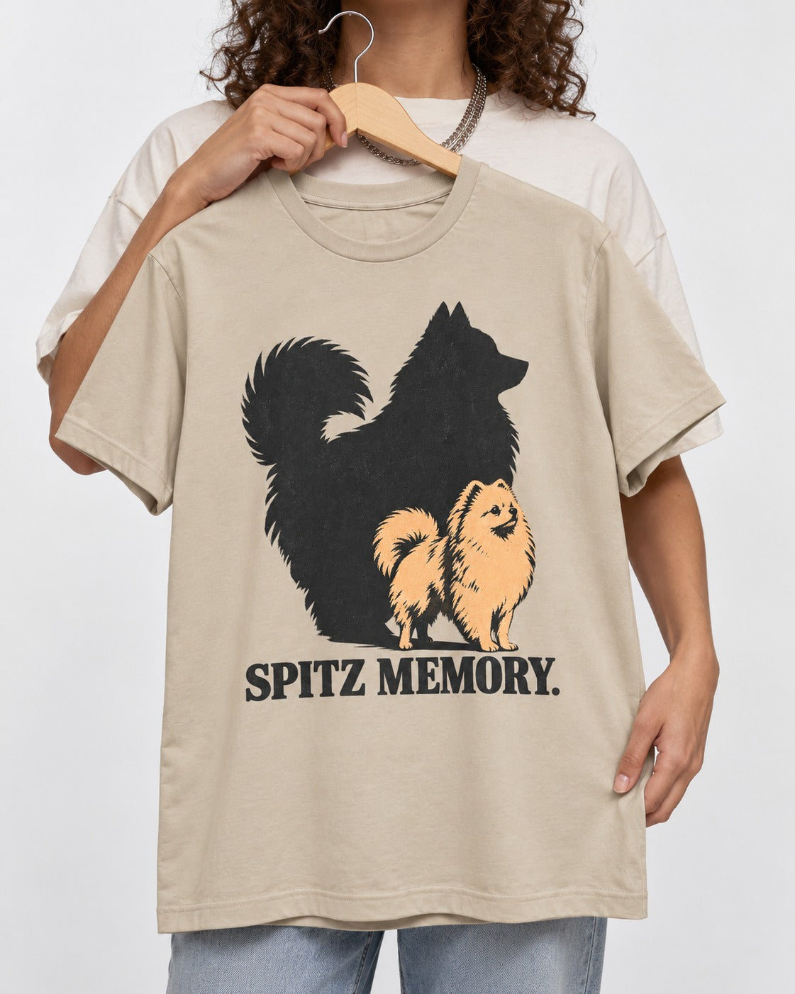 Pomeranian Spitz Memory T-Shirt in Sand, held up on a hanger