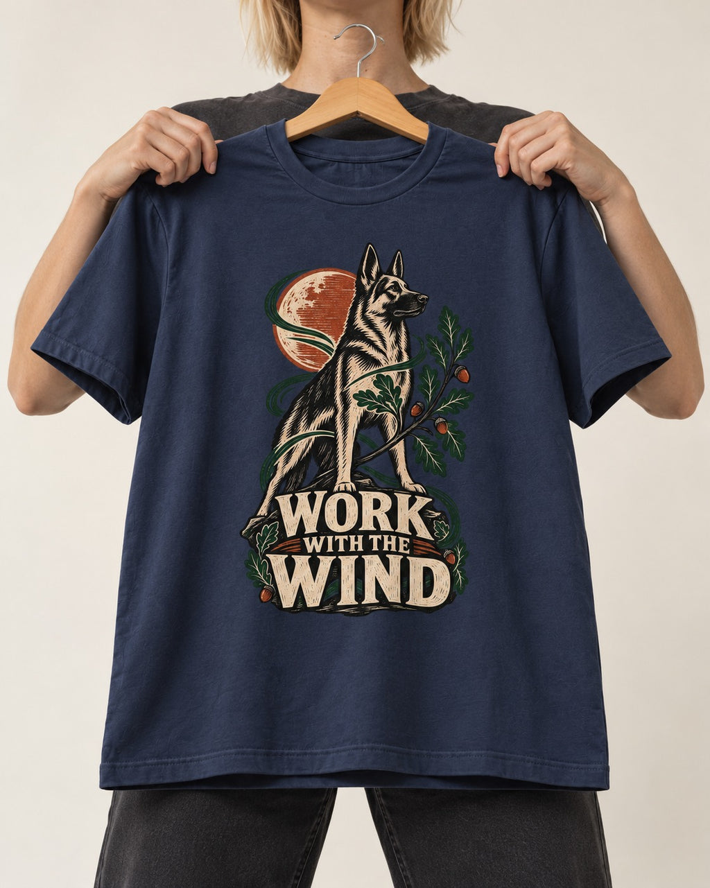 Work With The Wind Botanical Woodcut German Shepherd Dog Graphic T-Shirt in Navy, held up on a hanger